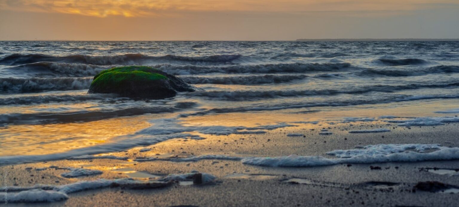 Bølgerne kommer rullende, ind over stenen i vandkanten ved Esbjerg, Danmark.