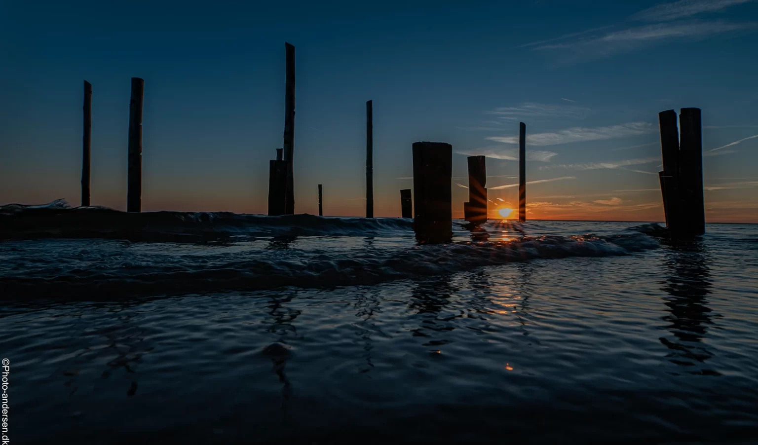 Hjerting pælene i solnedgangen ved Hjerting