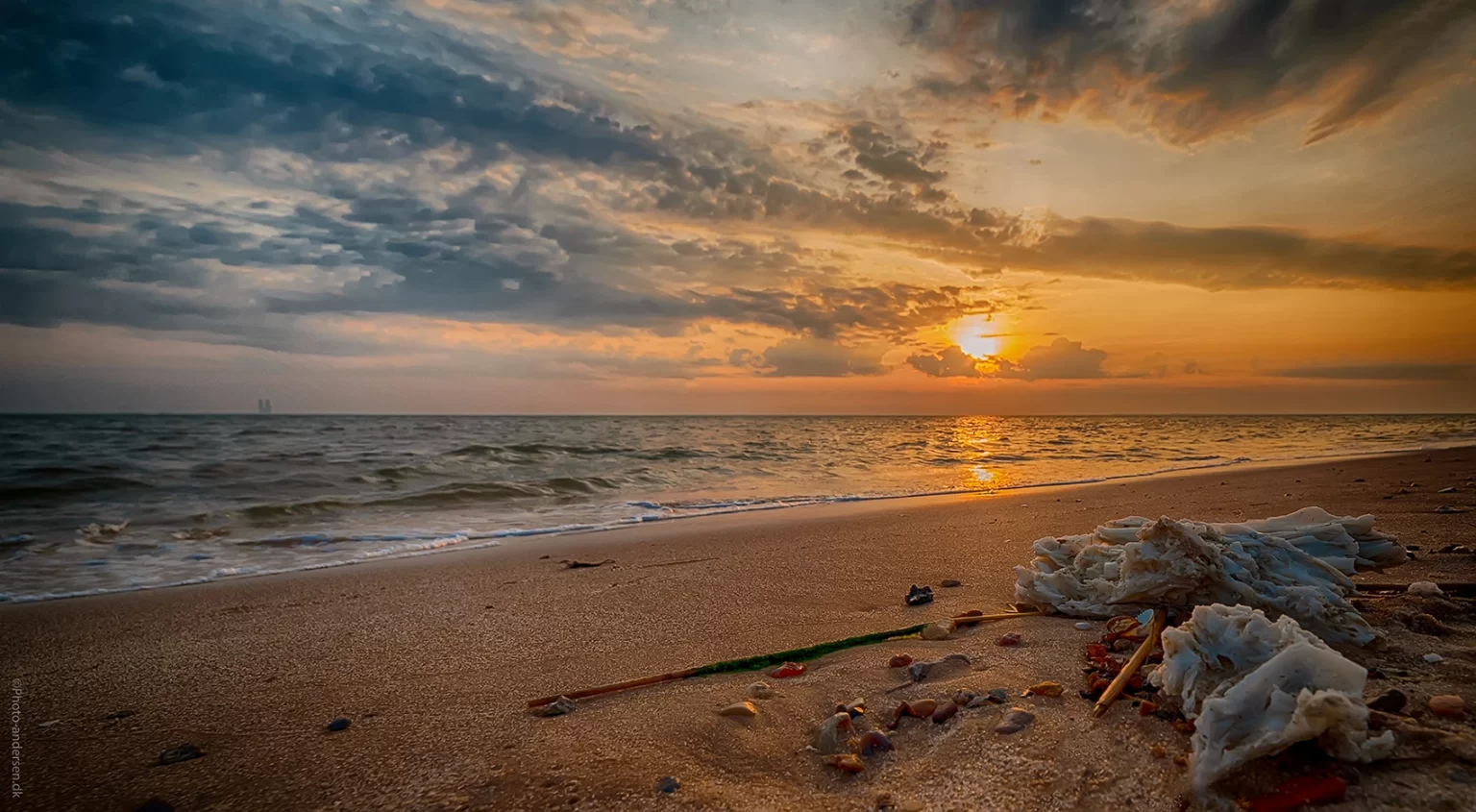 På stranden kan man bemærke spor af petroleum, der er skyllet op af havet, hvor det ligger ved Sædding strand ved Esbjerg, Danmark