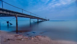 Badebroen ligger så unikt, smukt ud i landskabet ved Sjelborg, Esbjerg, Danmark. Hvor den ligger så smukt i blålige farver og hvor krabben er på vej ud i højvandet